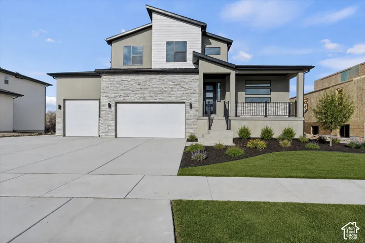 Contemporary exterior with multiple rooflines, stone and stucco facade, and two garage doors