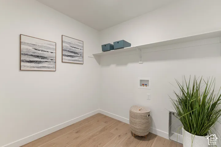Bright interior space with wood-finish flooring and a white built-in shelf