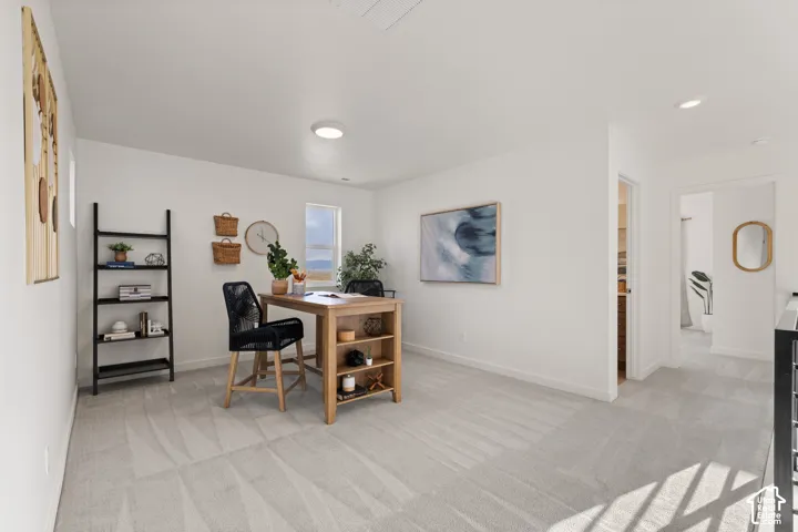 Brightly lit room featuring neutral carpeting, a window, and recessed lighting