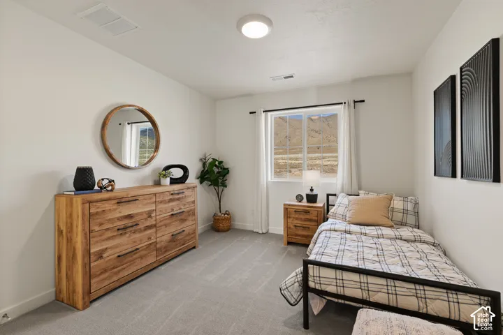 White walls with a single window, recessed lighting, and light gray carpeting