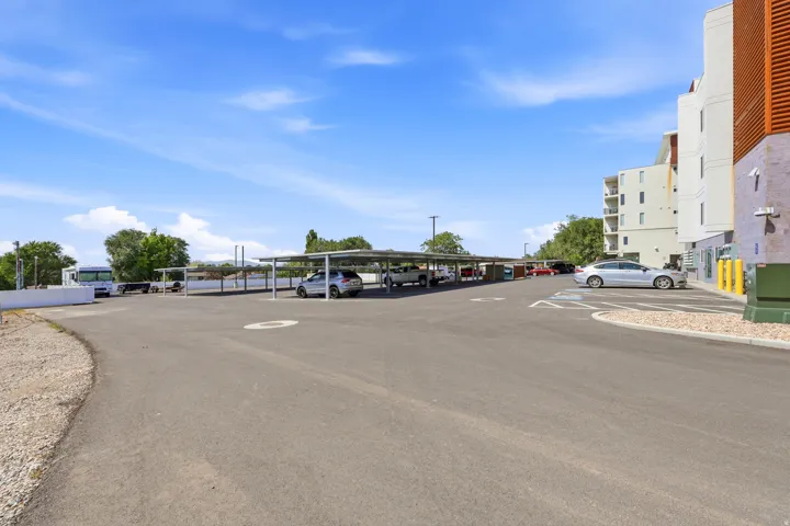 Paved parking area with multiple covered parking structures and designated accessible parking