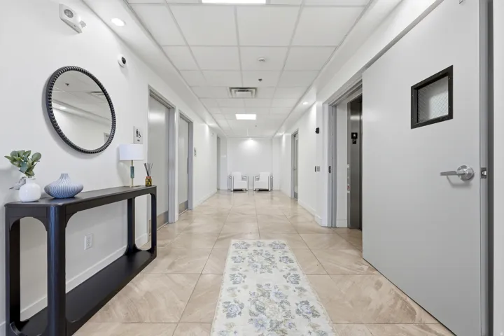 Neutral tile flooring, recessed ceiling lighting, and a drop ceiling