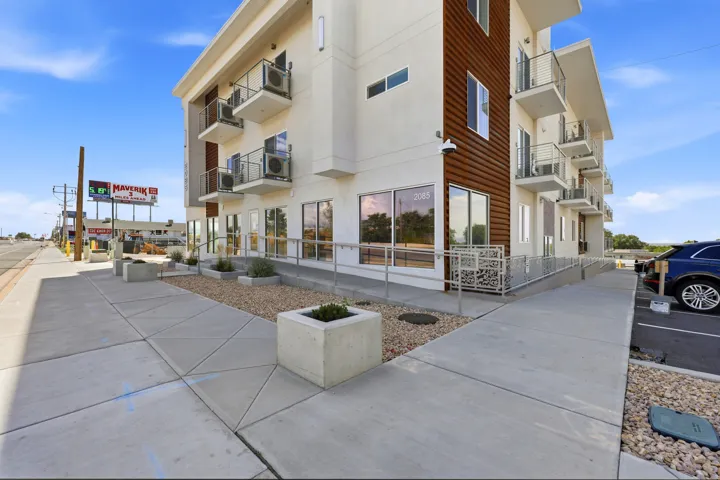 Modern multi-story building featuring a white facade and wood-finish siding