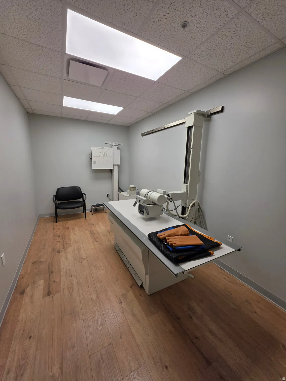Wood-finish flooring with light gray walls and recessed fluorescent lighting