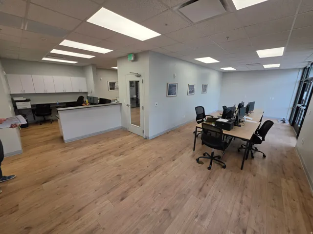 Recessed lighting, wood-finish flooring, white built-in cabinetry, and a glass-paneled door