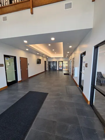 Recessed lighting throughout, high ceilings, wood-finish trim, and dark tile flooring