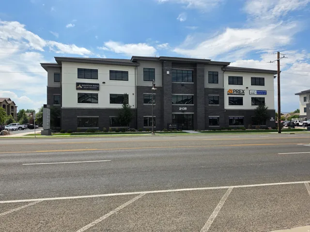 Modern commercial building featuring a multi-tone facade, ample window coverage, and dedicated tenant signage