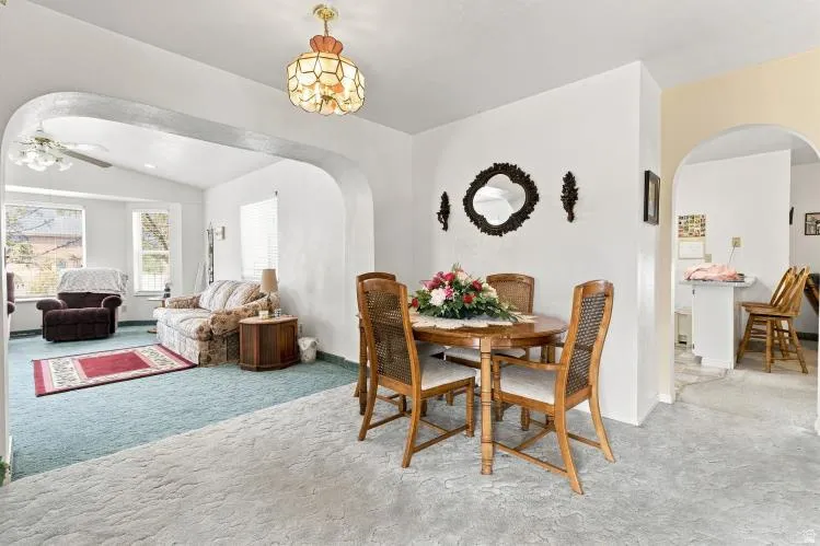 Arched doorway opening to living area with vaulted ceiling and ceiling fan