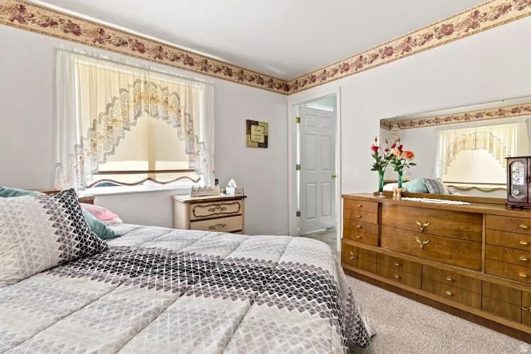 Wall-to-wall carpeting and white walls with decorative border