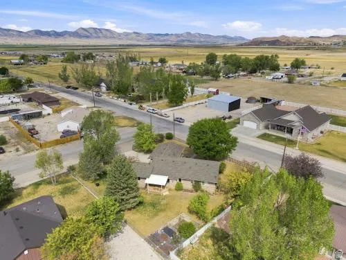 Expansive rural setting with mountain backdrop and open fields