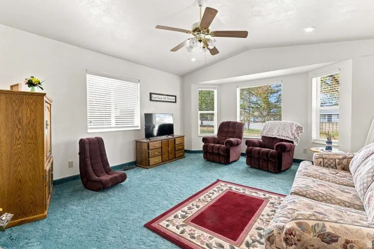 Vaulted ceiling, ceiling fan, bay windows, recessed lighting, and wall-to-wall carpeting