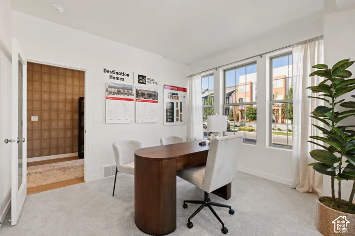 Carpeted room with multiple windows, providing ample natural light