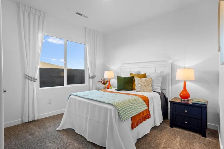 White painted walls, carpeted flooring, and a large window with white trim