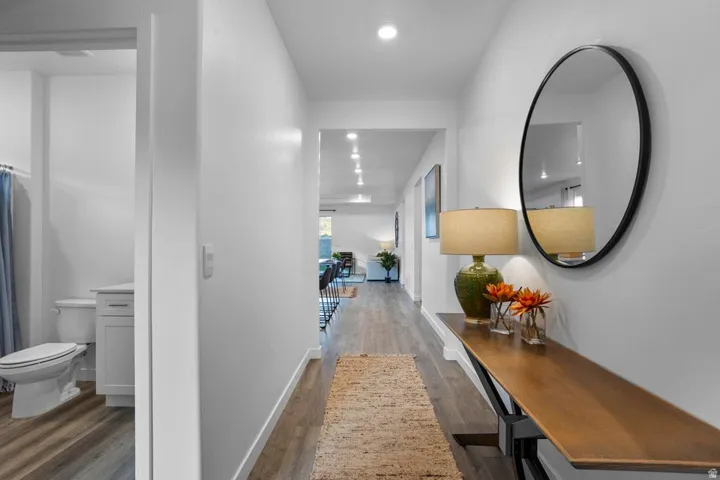 Hallway featuring wood-finish flooring, recessed lighting, and a console table