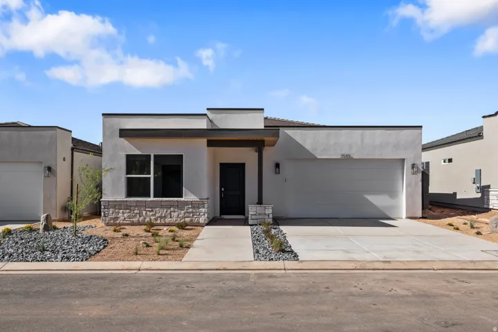 Modern stucco exterior with stone accents, a single-car garage, and a covered entry
