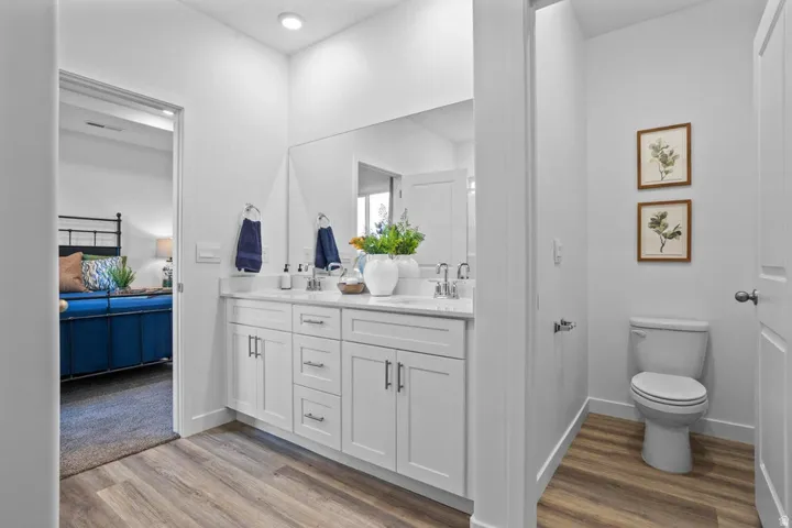 Dual vanity with white shaker-style cabinetry, undermount sinks, and a large mirror