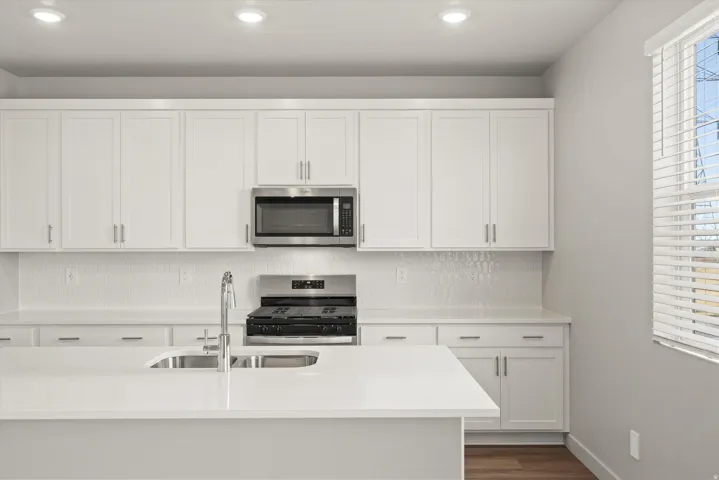 **DISCLAIMER**   Interior package upgrades not photographed. Modern kitchen featuring white shaker cabinetry, stainless steel appliances, a tile backsplash, and recessed lighting