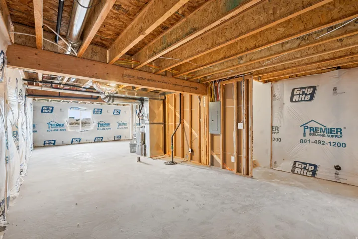 Unfinished basement featuring exposed wood joists and subfloor, concrete flooring, and insulated perimeter walls