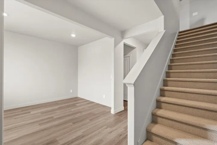 **DISCLAIMER**   Interior package upgrades not photographed. Recessed lighting, wood-finish flooring, and a carpeted staircase with a painted handrail
