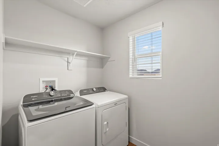 **DISCLAIMER**   Interior package upgrades not photographed. Laundry area featuring a window with blinds and wall-mounted shelving