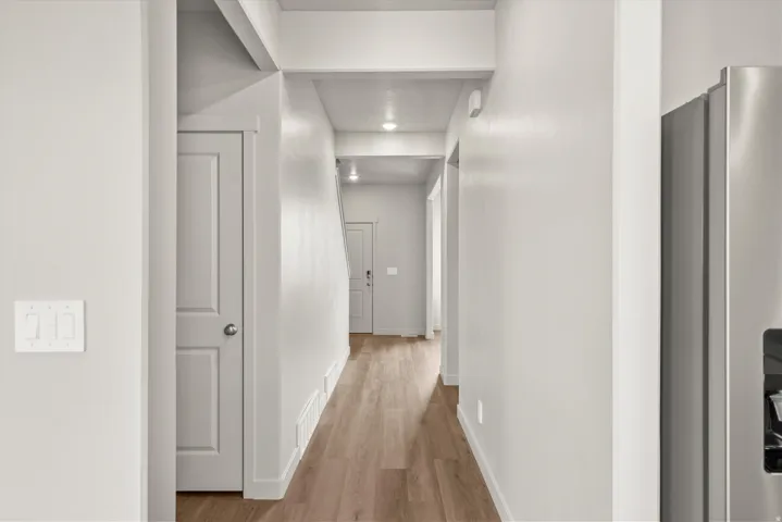 **DISCLAIMER**   Interior package upgrades not photographed.  Hallway featuring wood-finish flooring, recessed lighting, and a paneled interior door
