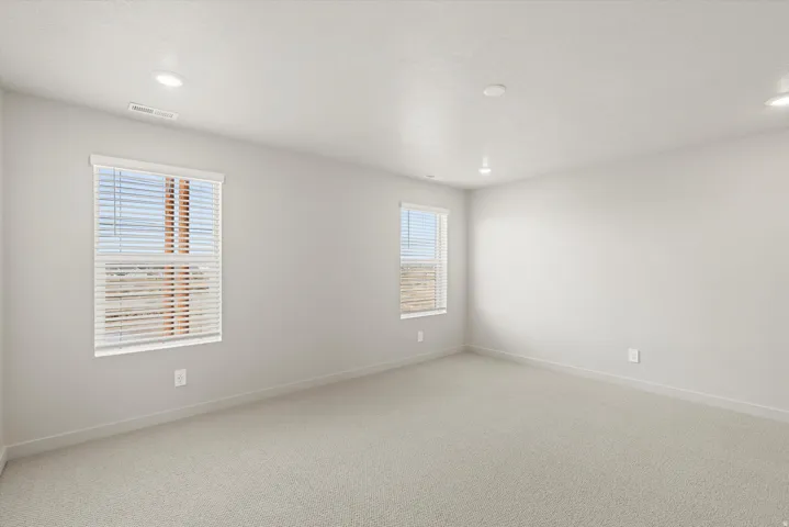 **DISCLAIMER**   Interior package upgrades not photographed. Recessed lighting fixtures, two windows with blinds, light-colored carpeting, and light-toned wall finishes
