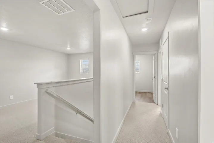 **DISCLAIMER**   Interior package upgrades not photographed. Carpeted upper-level landing with painted railing, recessed lighting, and white interior doors