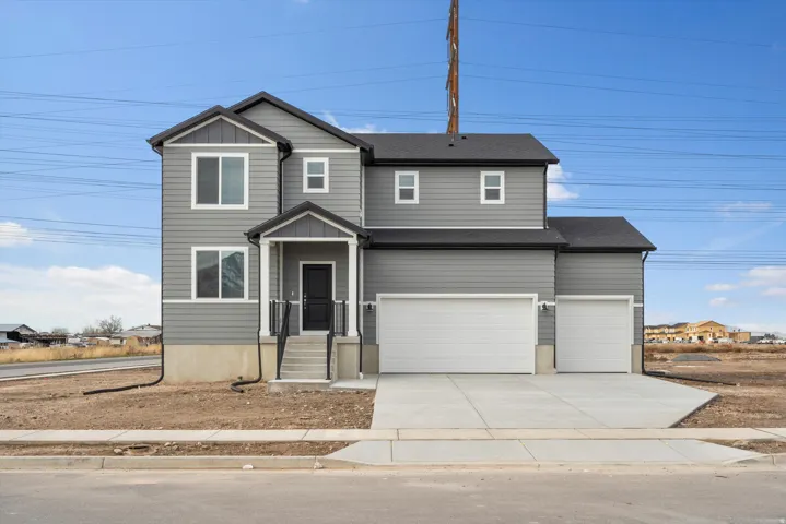 **DISCLAIMER** Elevation may vary.  Two-story residence featuring gray siding, a covered front entry, and a multi-car garage with a concrete driveway