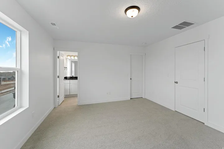 Light-toned carpeting, white walls, and a window with exterior views