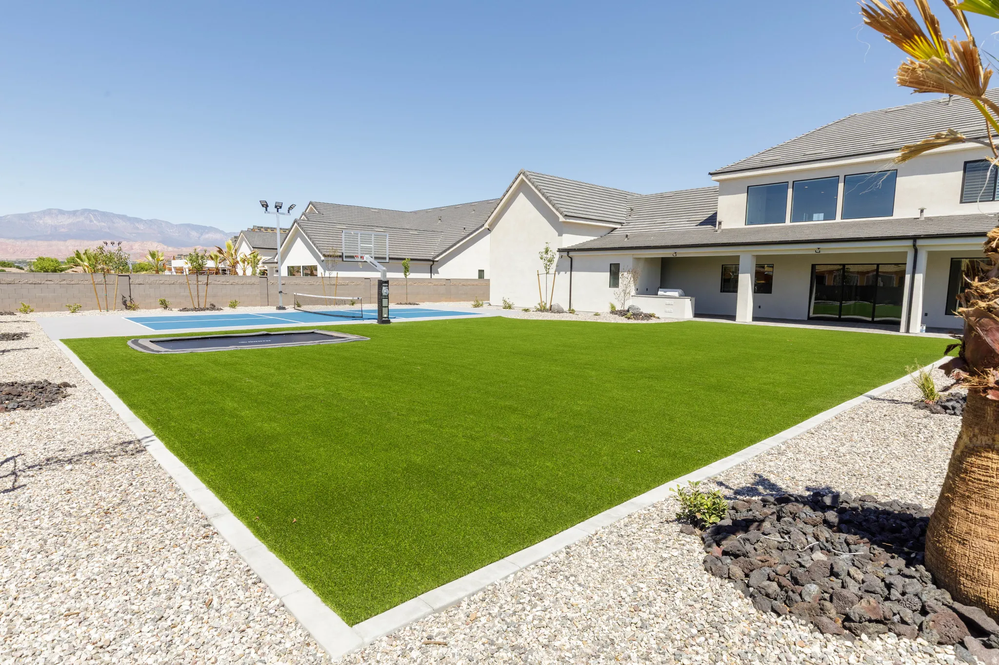 Expansive artificial turf lawn with integrated trampoline