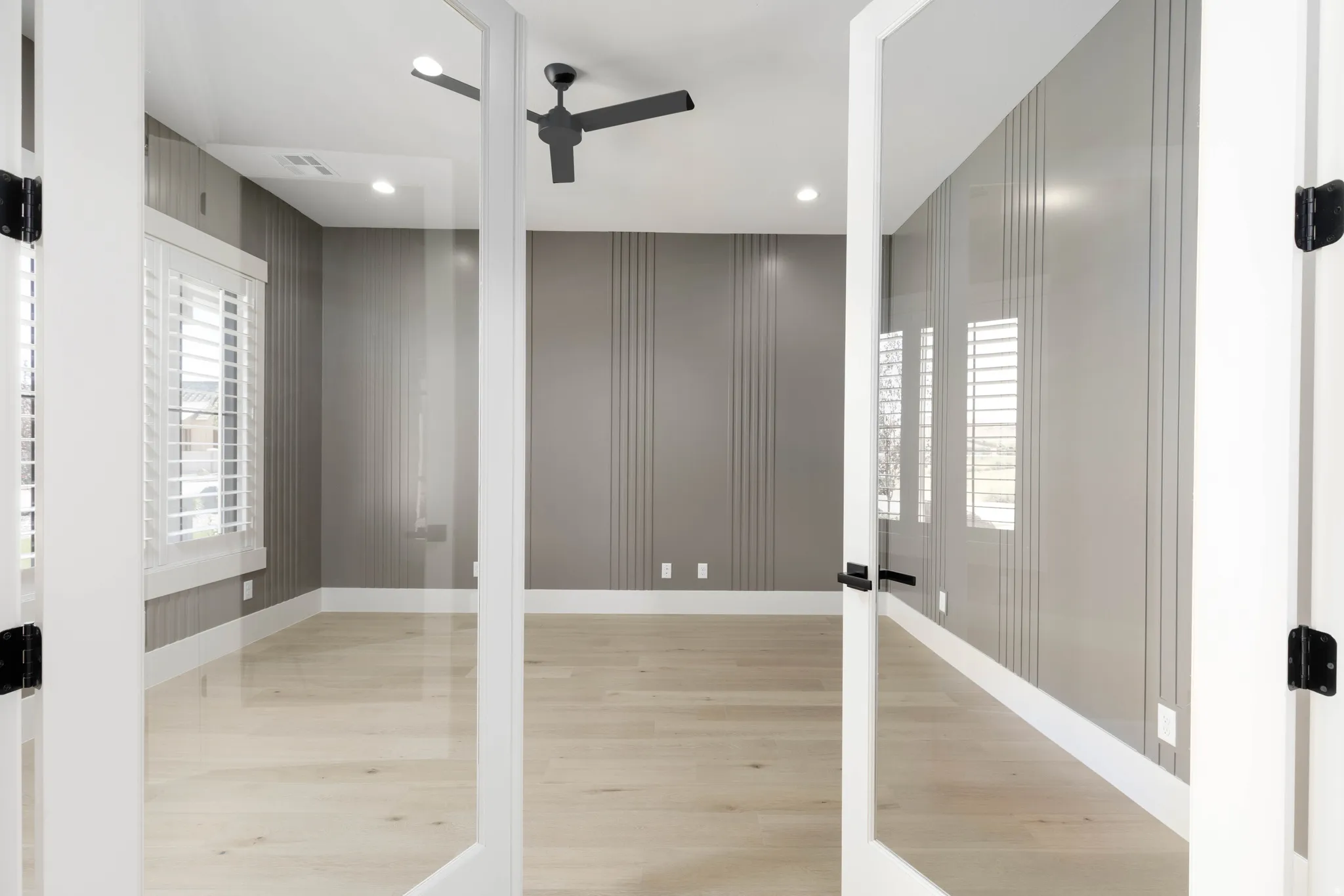 Spacious room featuring light wood-finish flooring, recessed lighting, and a ceiling fan