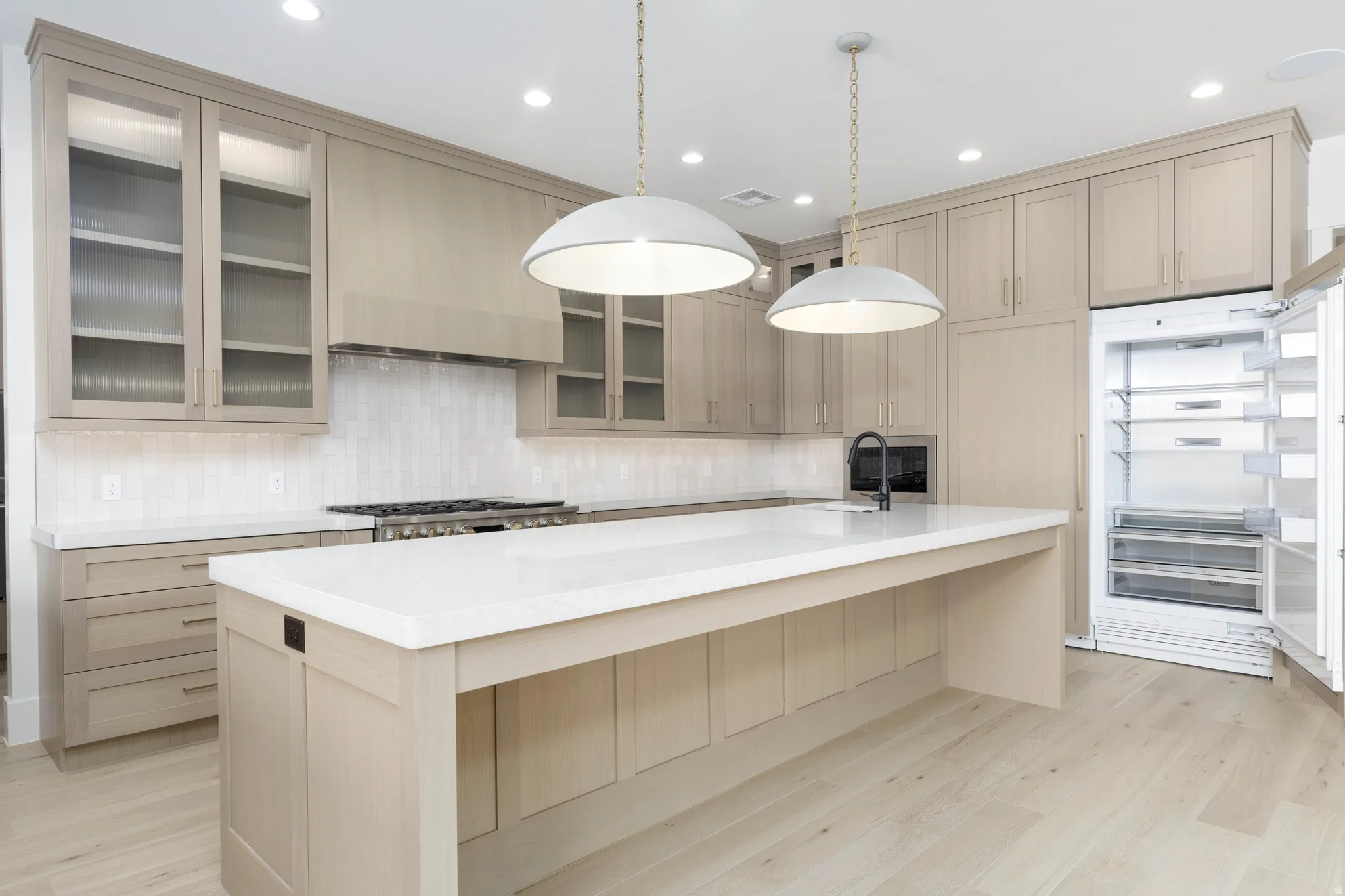 Light wood-finish flooring with a kitchen island featuring a white countertop