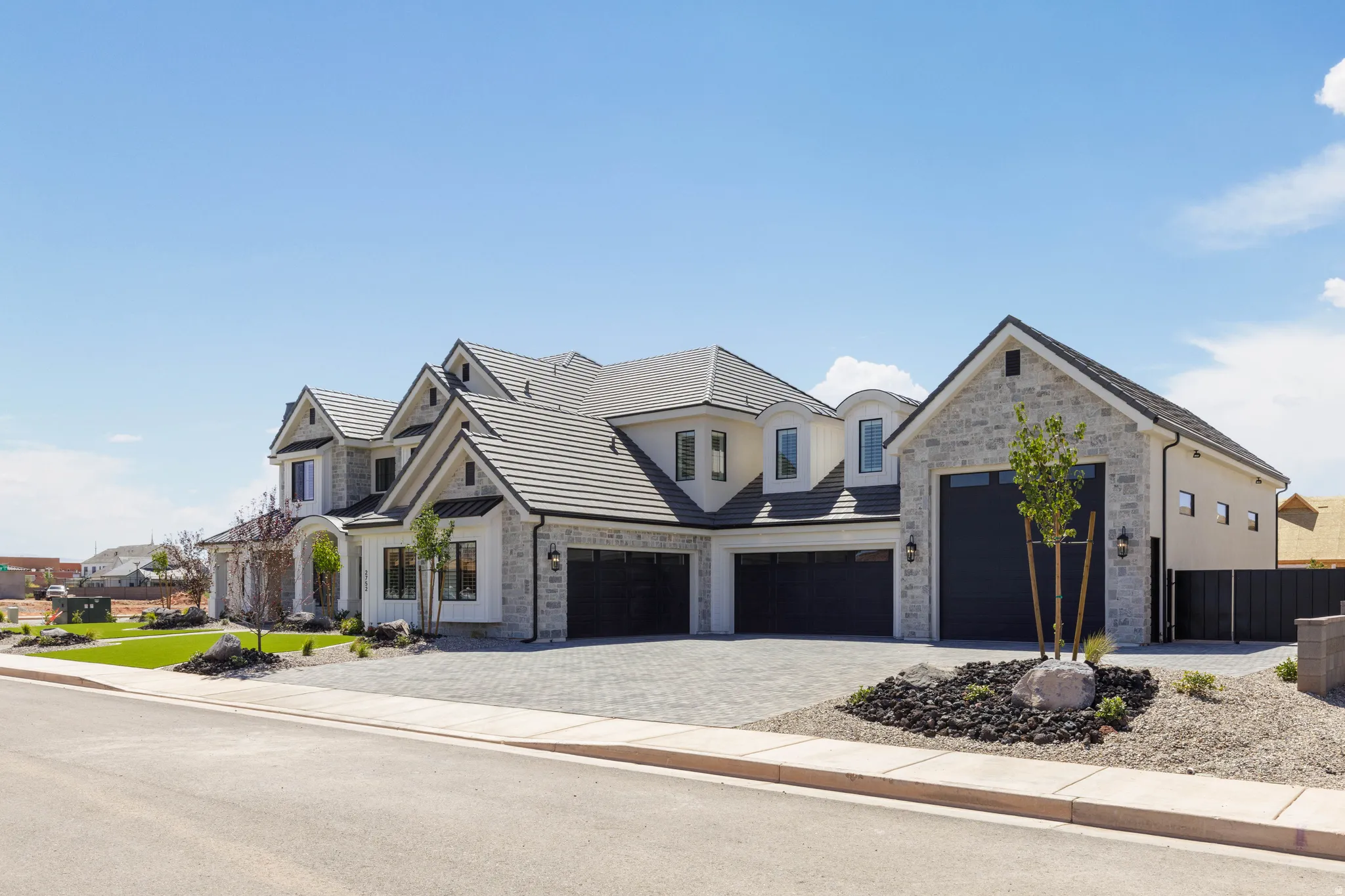 Stone and stucco exterior with multiple gables and dark gray roofing