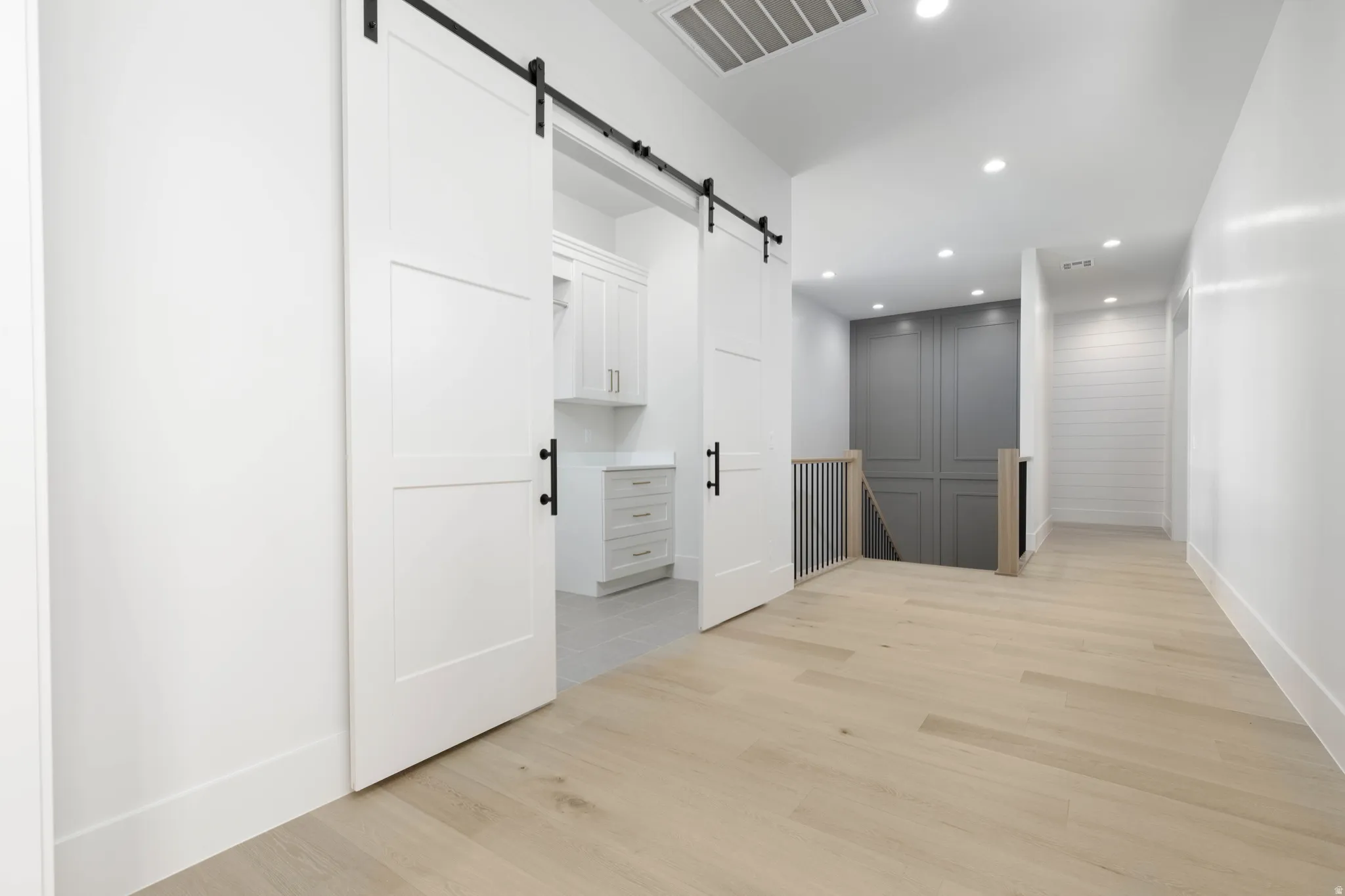 Wood-finish flooring, recessed lighting, and a white shiplap accent wall