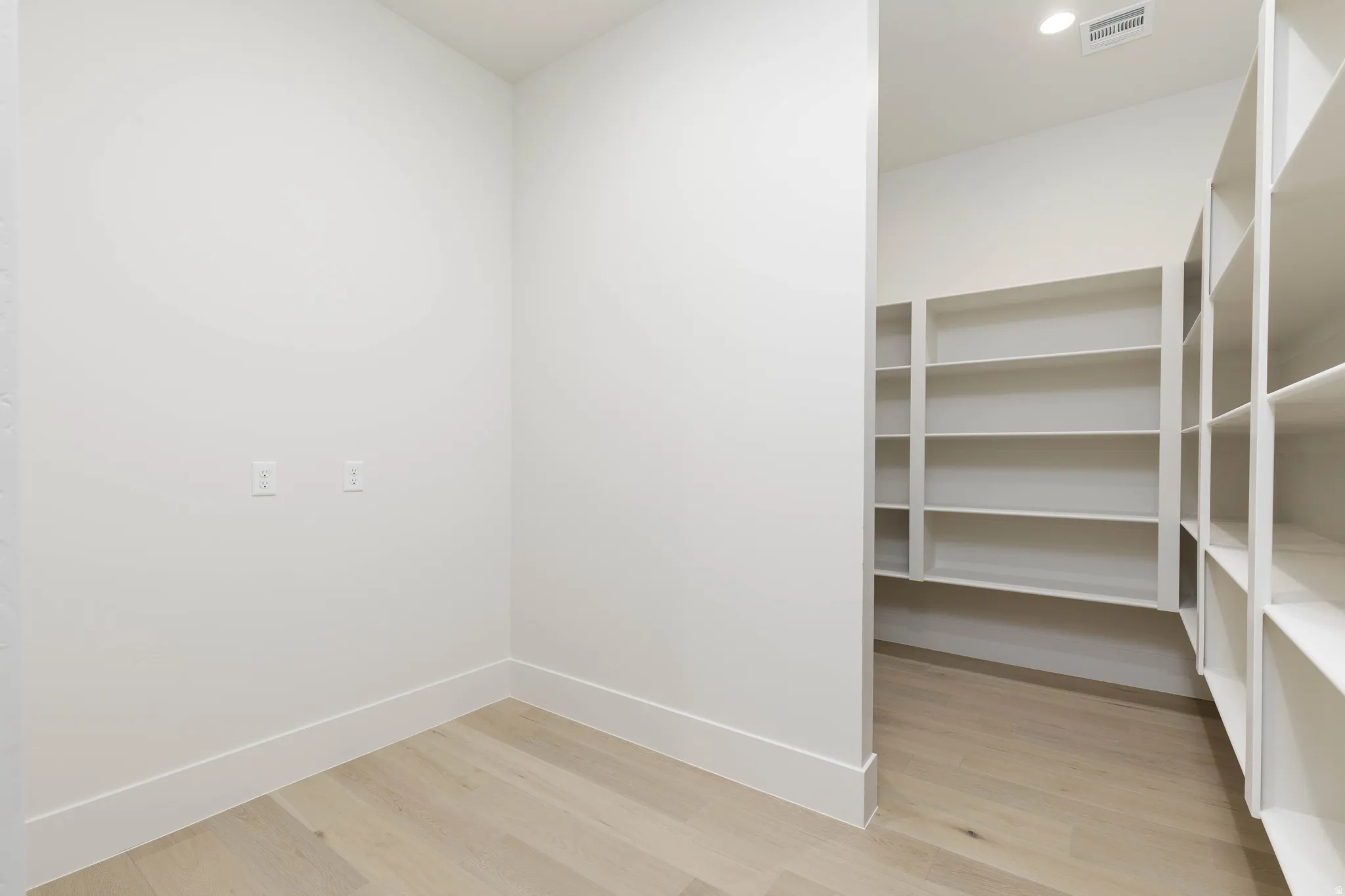 Built-in shelving, recessed lighting, and wood-finish flooring