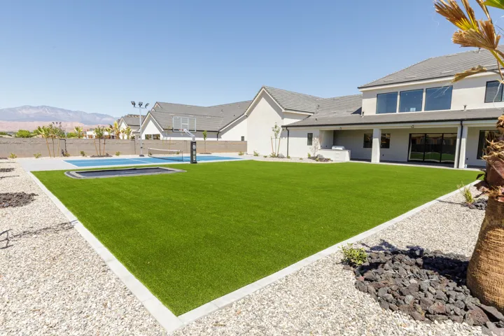 Expansive artificial turf lawn with integrated trampoline