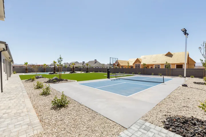 Outdoor sport court with a pickleball net and basketball hoop