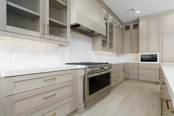 Gourmet kitchen featuring extensive cabinetry with brass hardware, stainless steel range, and a built-in microwave