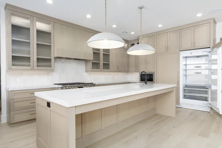 Light wood-finish flooring with a kitchen island featuring a white countertop