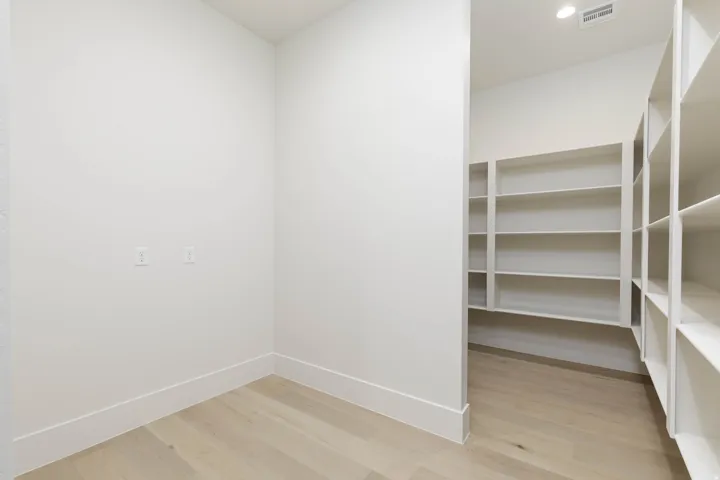 Built-in shelving, recessed lighting, and wood-finish flooring