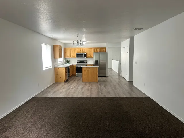 Kitchen with wood cabinetry, stainless steel appliances, and a central island