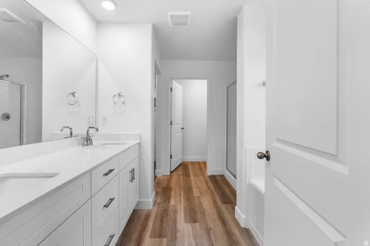 Dual vanity with undermount sinks, chrome fixtures, and white cabinetry