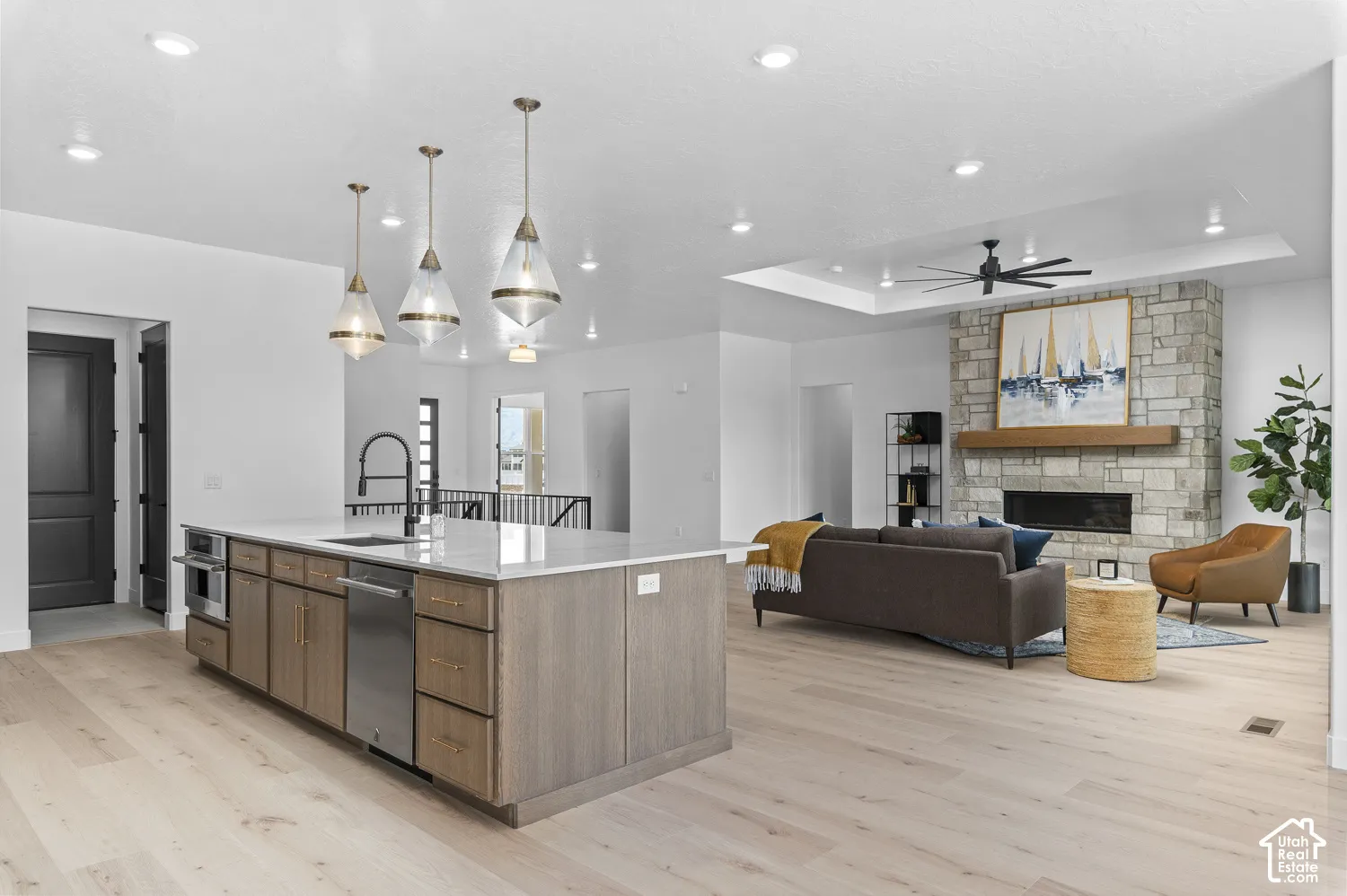 Expansive kitchen island with a light-toned countertop, integrated stainless steel appliances, and wood-finish cabinetry