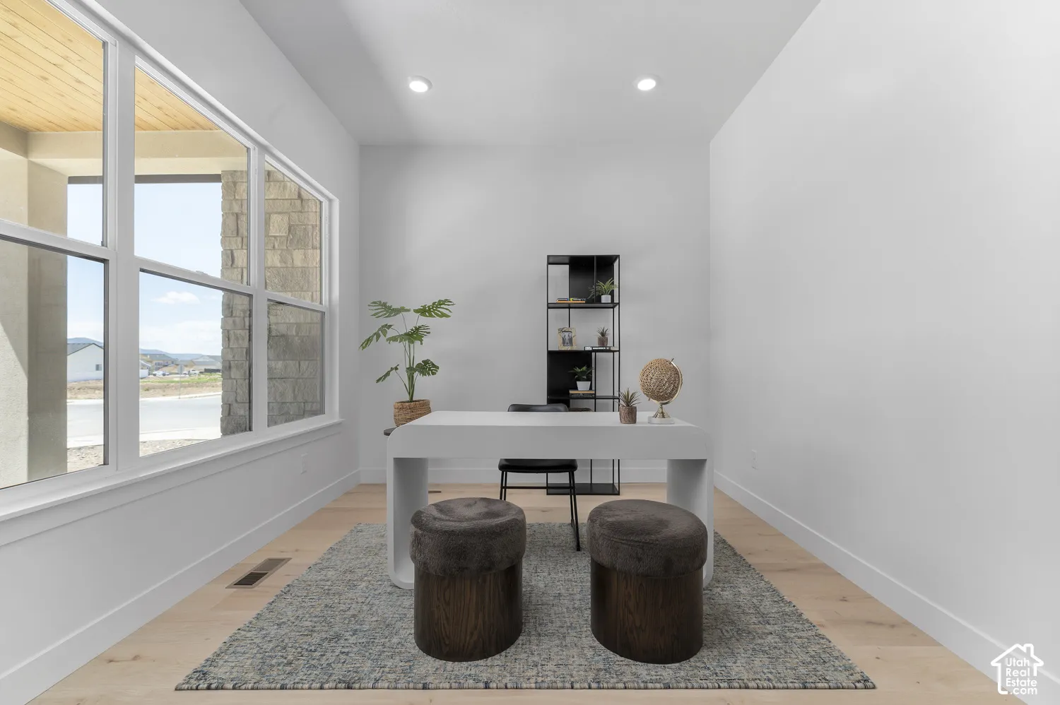 Expansive window with white framing, wood-finish flooring, recessed ceiling lighting, and a built-in shelving unit