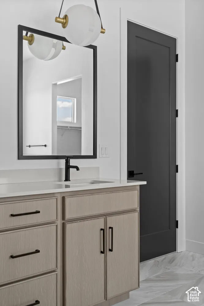 Light wood-finish vanity with black hardware, white countertop, and integrated sink