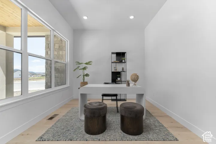 Expansive window with white framing, wood-finish flooring, recessed ceiling lighting, and a built-in shelving unit