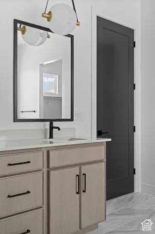 Light wood-finish vanity with black hardware, white countertop, and integrated sink