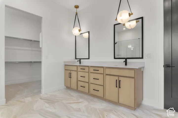 Dual vanity with light wood-finish cabinetry, matte black hardware, and integrated sinks