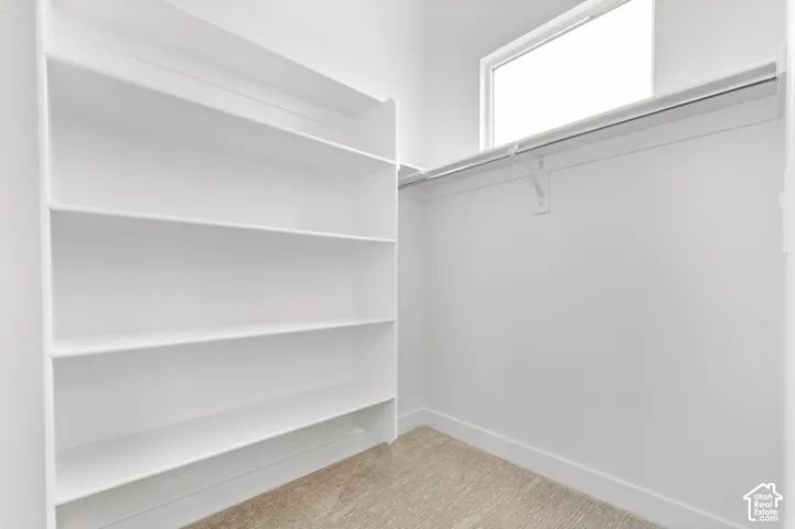Integrated shelving, upper storage rod, and natural light from transom window
