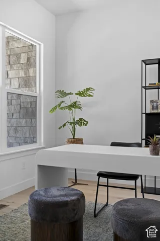Light wood-finish flooring with a white desk and built-in shelving